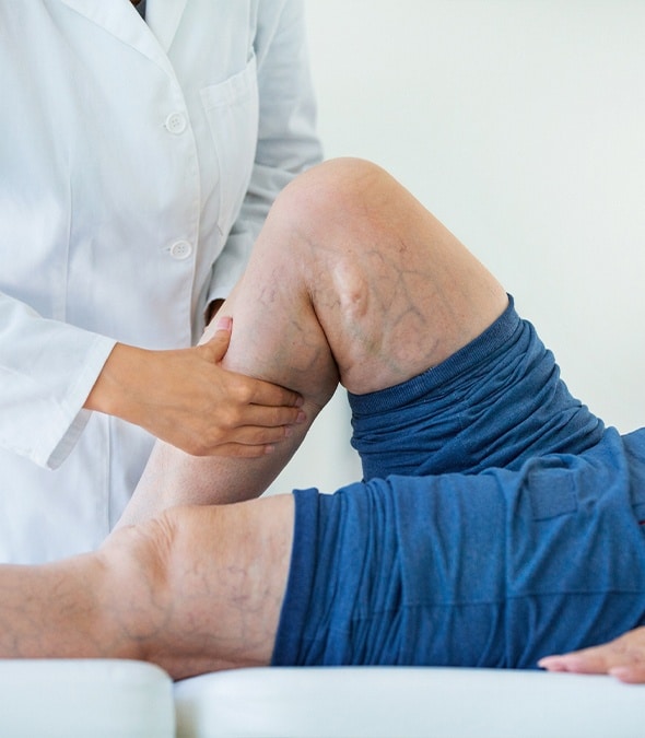 Dermatologist inspecting a patient's leg veins