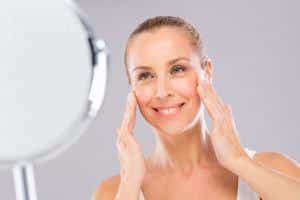Woman moisturizing her face