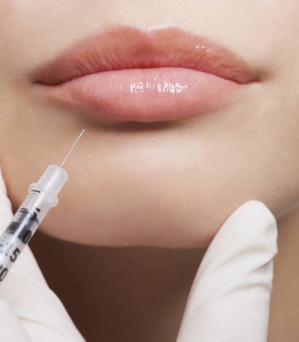Close up of woman receiving botox injection in her lips